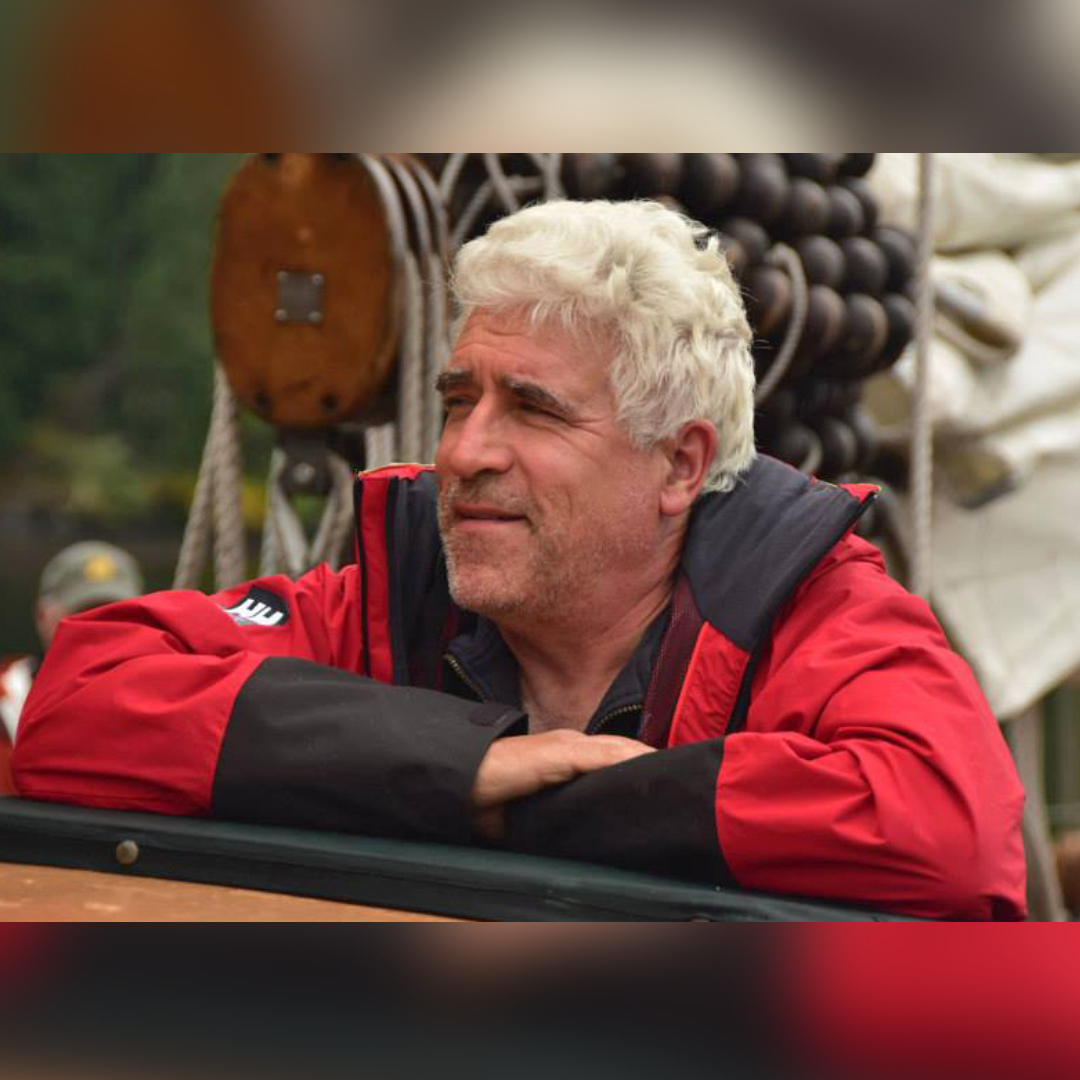 A man with white hair sitting at the table.